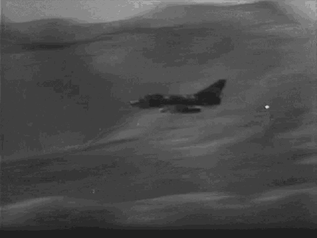 a black and white photo of smoke coming out of a hillside