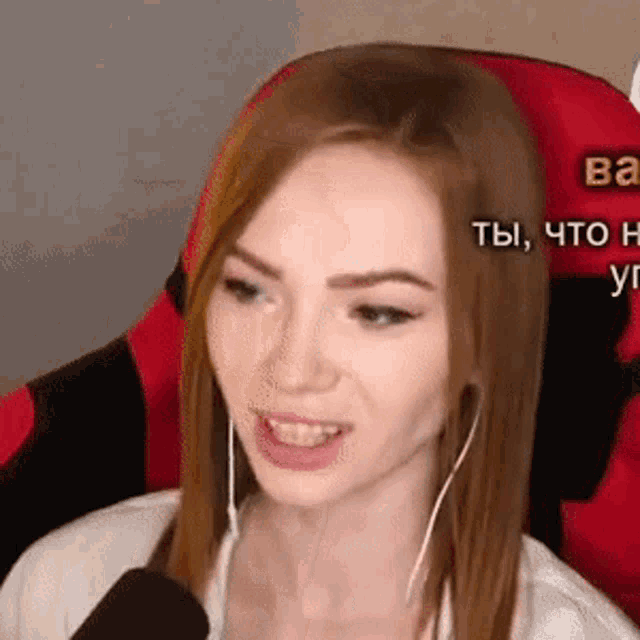 a woman is sitting in a red chair with a microphone and headphones on .