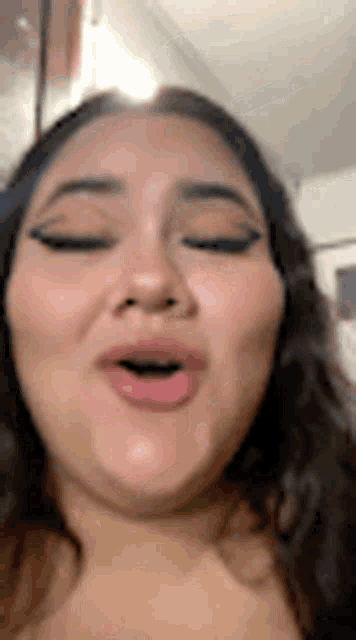 a close up of a woman 's face with her eyes closed .