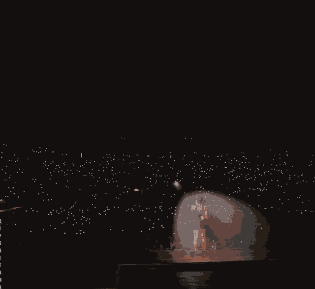 a woman singing into a microphone in front of a crowd