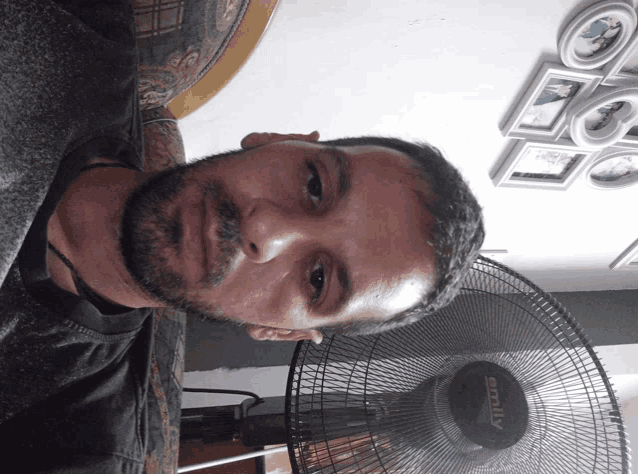 a man with a beard is sitting in front of a fan that says sonify on it