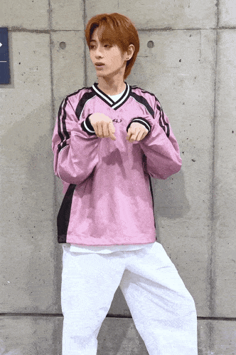 a person wearing a pink sweatshirt and white pants