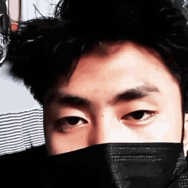 a close up of a person wearing a black face mask