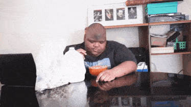 a man sitting at a table eating cereal and milk