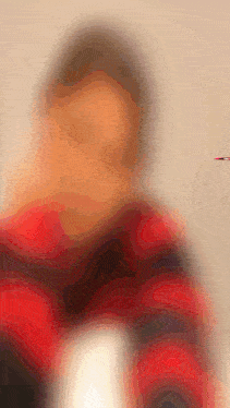 a blurred image of a person with a red jacket on