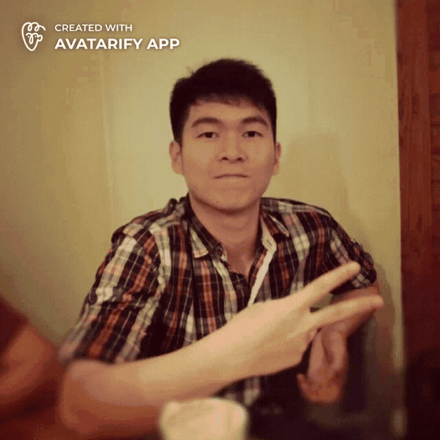 a man in a plaid shirt is making a peace sign with his hand