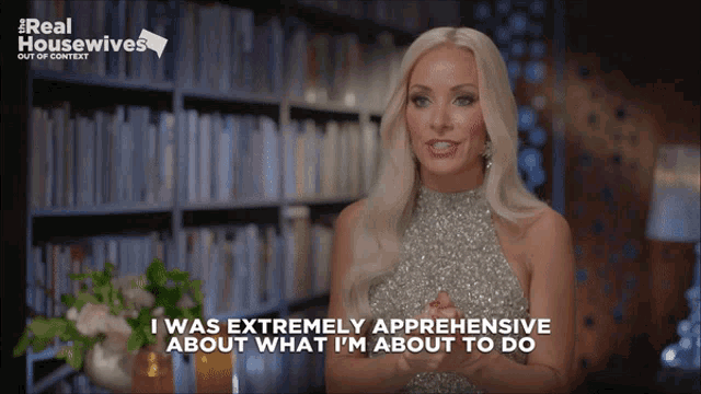 a woman says i was extremely apprehensive about what i 'm about to do in front of a bookshelf