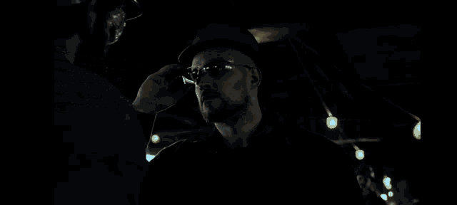 a close up of a person 's hand holding a hammer in the dark