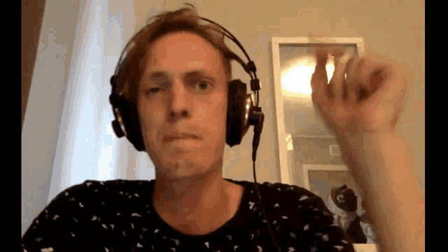 a man wearing headphones is making a funny face in front of a mirror .