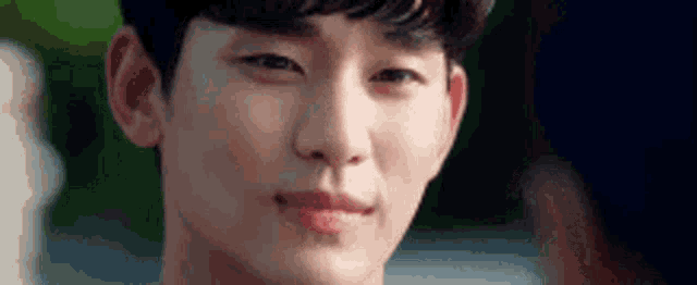 a close up of a young man 's face with a slight smile on his face .