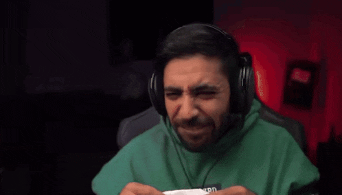 a man wearing headphones is eating a piece of paper .