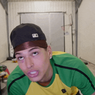 a man wearing a green and yellow shirt and a black hat with a mlb logo