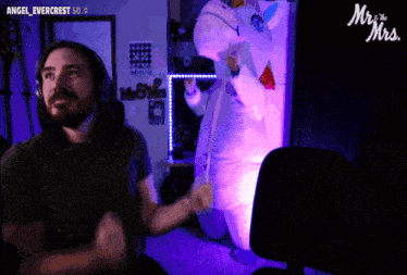 a man wearing headphones looks at a stuffed unicorn in front of a sign that says mr. & mrs.