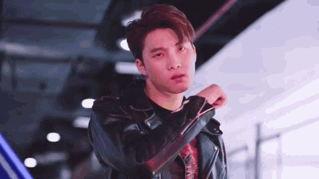 a young man wearing a leather jacket and a t-shirt that says ' i love you '