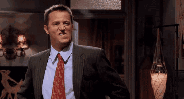 a man in a suit and tie making a face