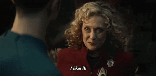 a woman with curly hair is talking to another woman and says i like it !
