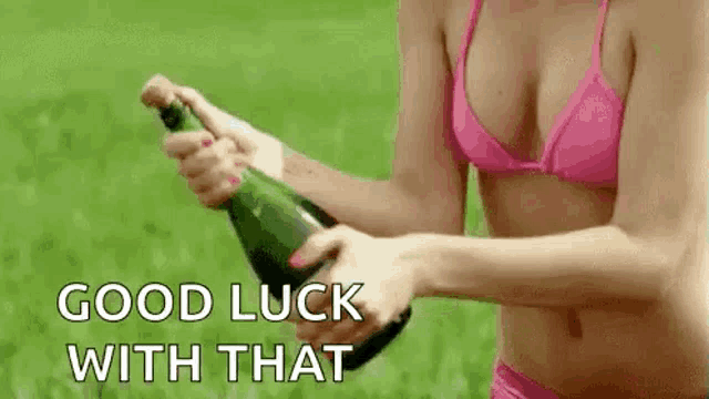 a woman in a bikini is holding a bottle of champagne and spraying it .