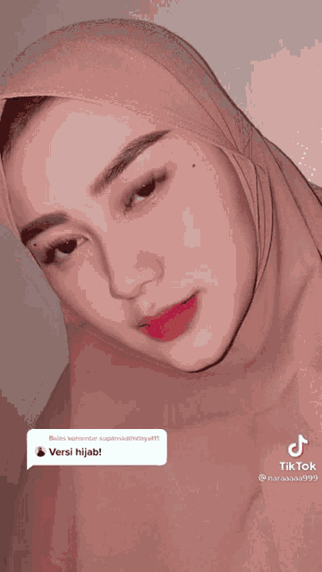 a close up of a woman wearing a hijab with a tiktok icon next to her