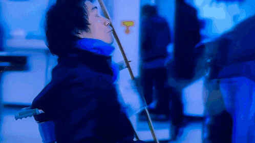 a blurry picture of a person holding a stick with the letter t in the background