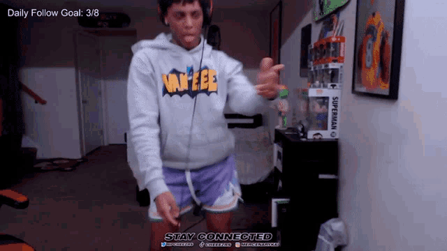 a man wearing a hoodie that says yankees is dancing in a room