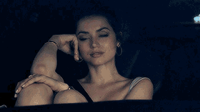 a woman is sitting in the back seat of a car with her hand on her face .