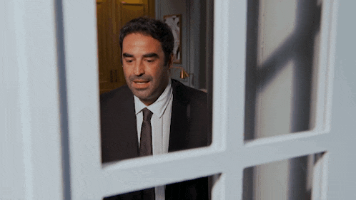 a man in a suit and tie is standing in a doorway .