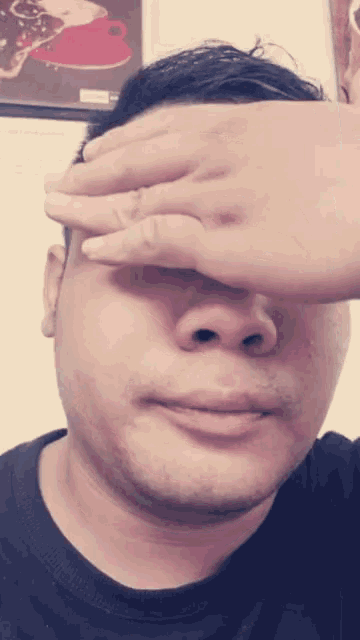 a man covering his eyes with his hand in front of a picture of a coffee cup