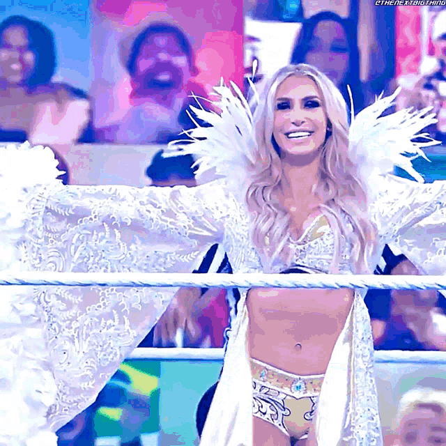 a woman in a white dress with wings is smiling in front of a crowd
