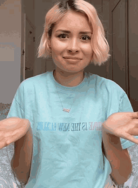 a woman wearing a t-shirt that says ' believe in the new future ' on it