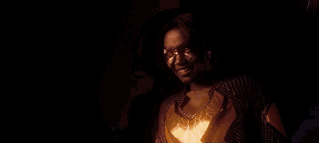 a woman wearing glasses and a yellow and black top smiles