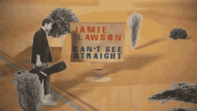 a man holding a guitar in front of a sign that says mie awson n't see straight