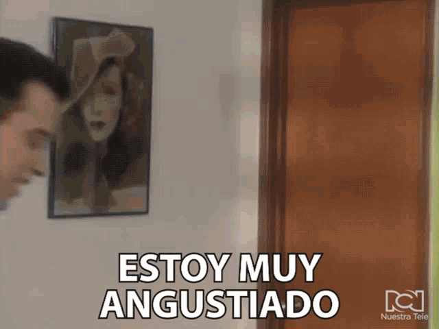 a man stands in front of a painting that says " estoy muy angustiado "