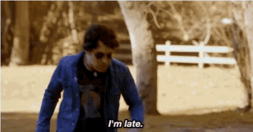 a man wearing sunglasses and a blue jacket says i 'm late