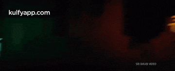 a blurry picture of a green and yellow logo on a black background