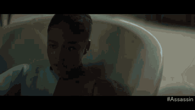 a woman sits in a bathtub with the hashtag #assassin