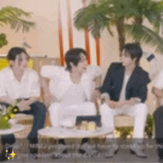 a group of people are sitting around a table and talking .