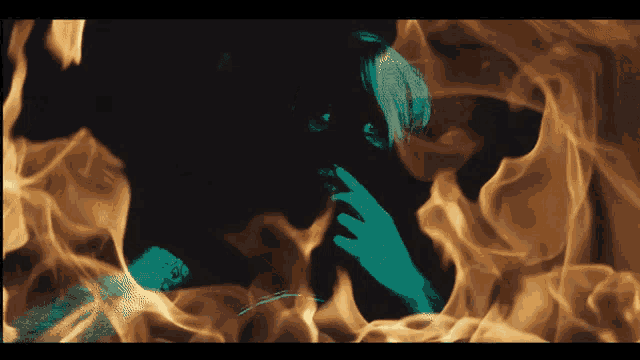 a woman 's face is surrounded by flames in a painting