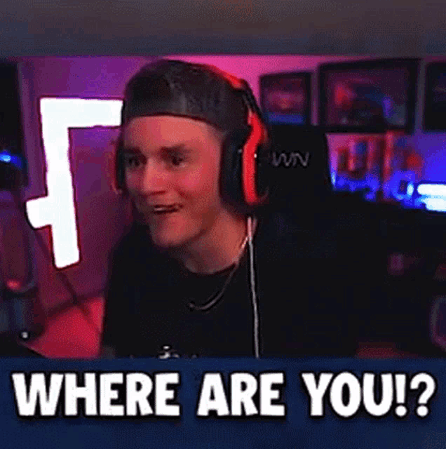 a man wearing headphones is sitting in front of a microphone in a video game room .