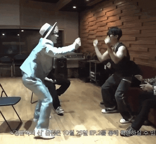 a man in a white hat is dancing with another man in a blue shirt