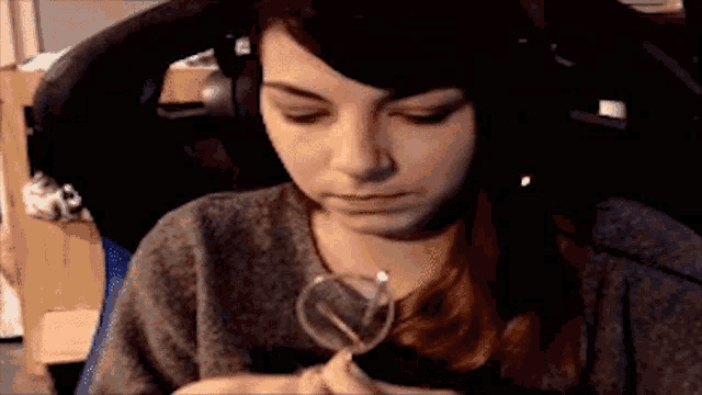a woman wearing headphones is sitting in a chair holding a heart shaped object .