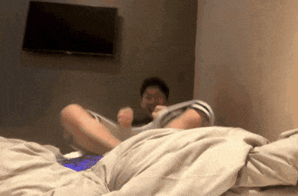 a man is laying on a bed with his feet up