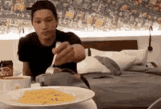 a man is eating a plate of food with a fork .