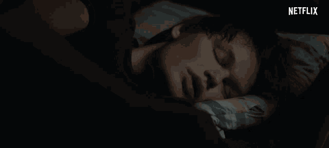 a person laying in bed with a netflix logo in the background