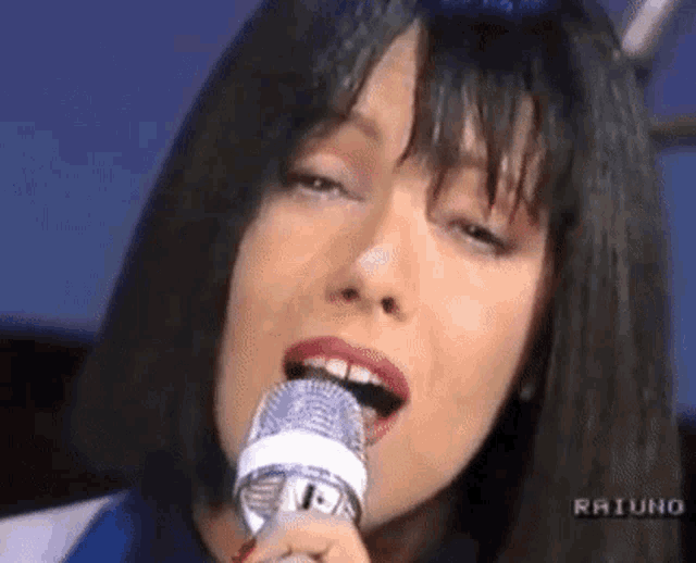 a woman is singing into a microphone .