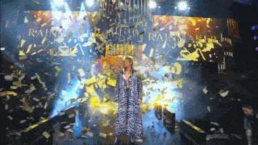 a man stands in front of a screen that says rainmaker on it