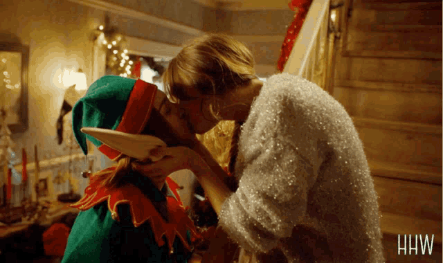 a woman kissing another woman in a sweater that says hw on it