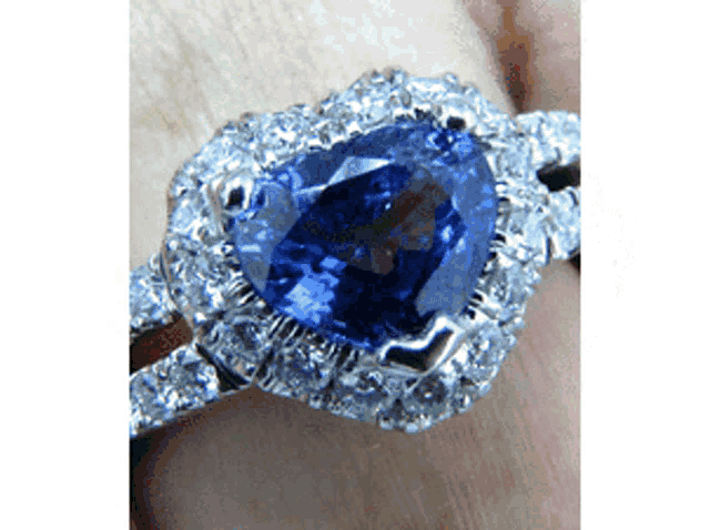 a close up of a ring with a heart shaped sapphire in the center