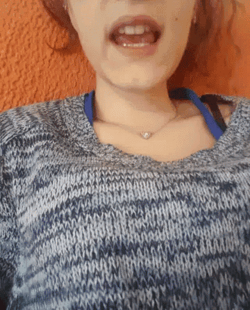 a woman wearing a blue and white sweater and a necklace