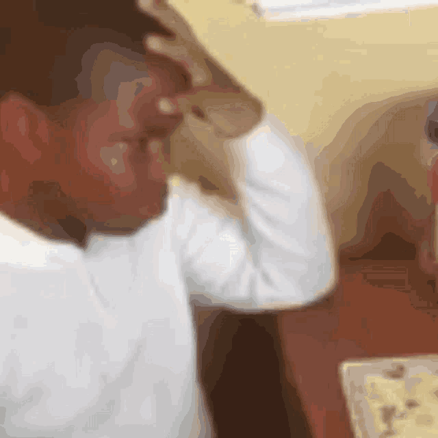 a blurry picture of a man holding his head
