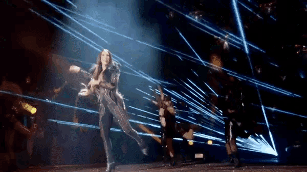 a woman is dancing on a stage in front of a crowd